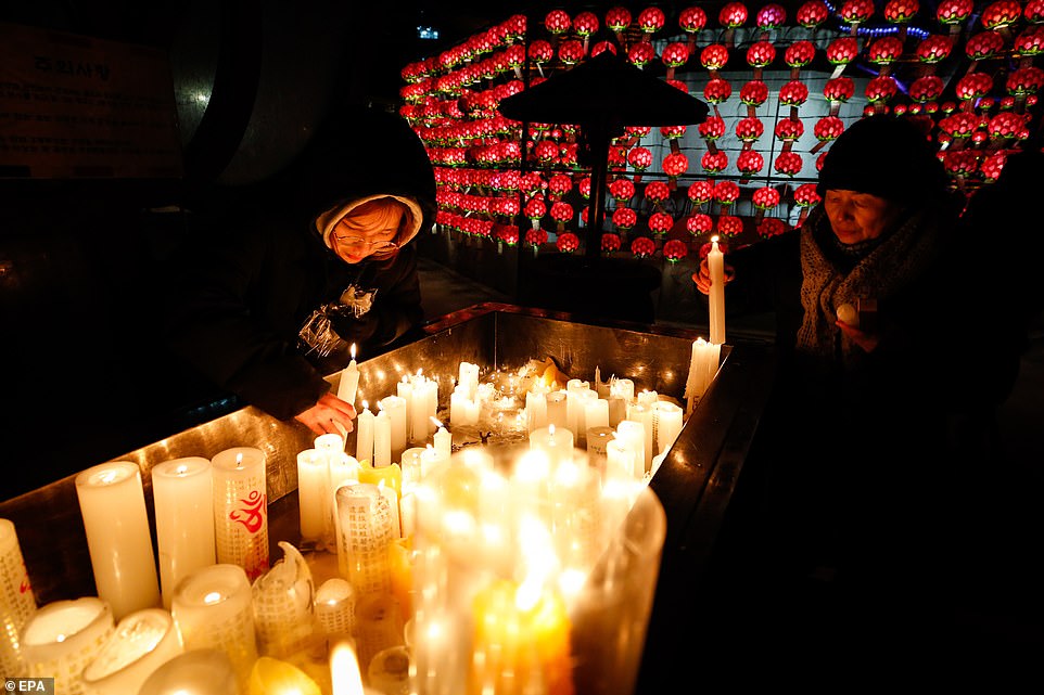 South Korean Buddhist devotees light candles as they pray at the Jogyesa temple on New Year's Eve in Seoul