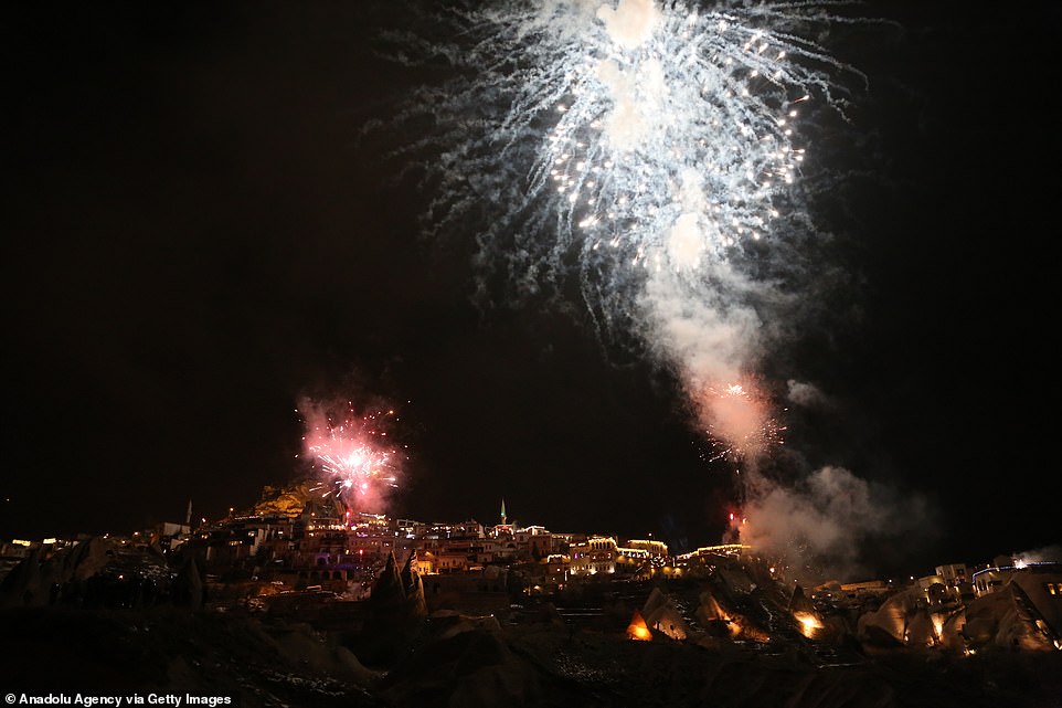 Fireworks illuminate the night sky over fairy chimneys, the famous volcanic rock formations at the historical region of Cappadocia, during the new year celebrations in Nevsehir, Turkey on January 01, 2020