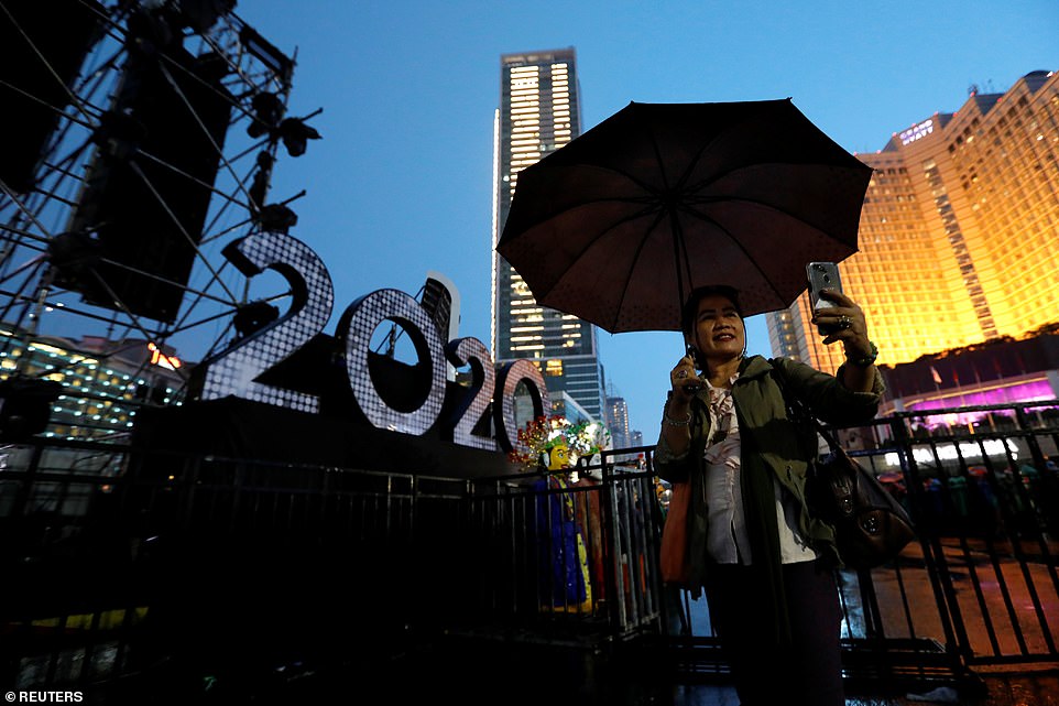 A woman takes selfie pictures next to 2020 decoration during New Year's Eve celebrations in Jakarta, Indonesia on December 31